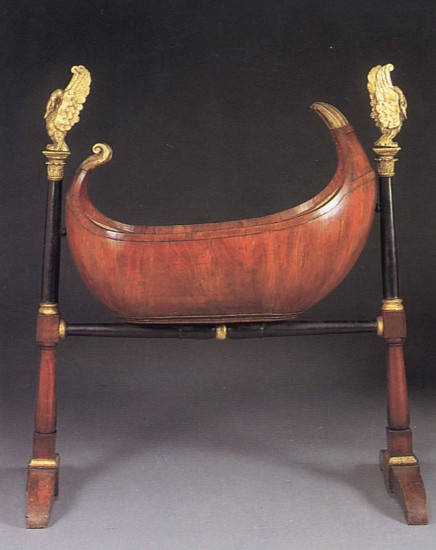 19th Century AUSTRIAN, Biedermeier Black Walnut, Ebonized and Parcel-Gilt Cradle, 1800-1825
Mixed woods, 59 1/2 x 49 1/4 x 20 1/2 in. (151.1 x 125.1 x 52.1 cm)
Rocking crib raised on ebonized columnar supports with corinthian capitals supporting later giltwood swans, the supports joined by a baluster-shaped stretcher ending in trestle legs.
BIE-003-FU